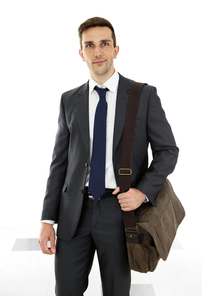 Man holding suitcase on light background - Foto, afbeelding
