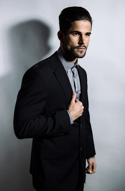 schöner junger Mann im Anzug auf grauem Hintergrund. Geschäftsmann - Foto, Bild