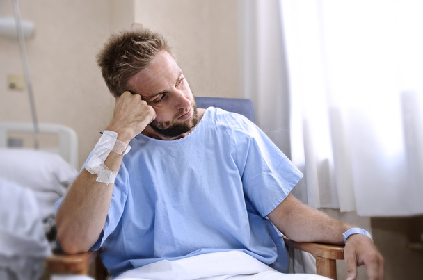 młody człowiek poszkodowanej w szpitalnej sali siedzi sama w bólu martwi się o jego stan zdrowia - Zdjęcie, obraz