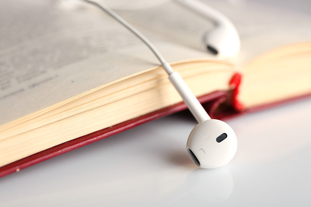 Earphones and book on table, closeup - Photo, image