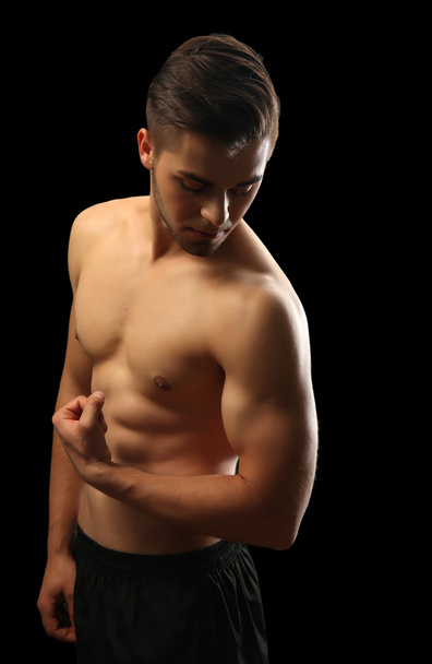 Muscle young man on dark background - Foto, afbeelding