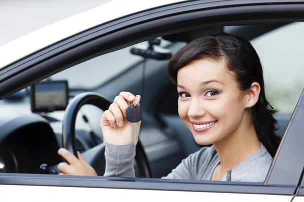hübsche asiatische Fahrerin in einem weißen Auto zeigt den Autoschlüssel - Foto, Bild