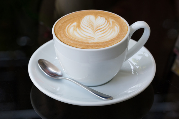 hete koffie latte, latte kunst met hart in een witte kop - Foto, afbeelding