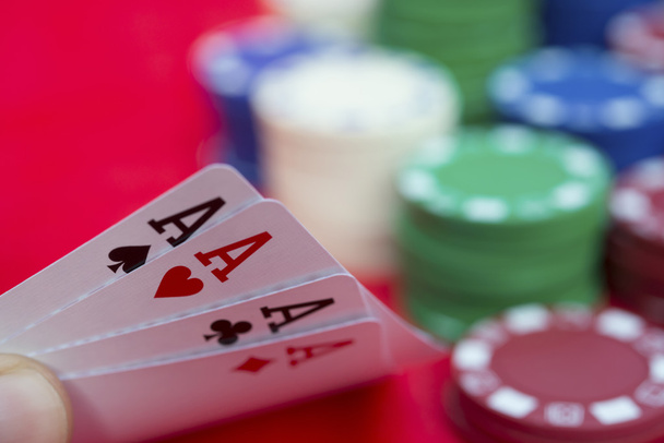giocatore di poker in possesso di 4 asso di poker accanto a un sacco di chip
 - Foto, immagini