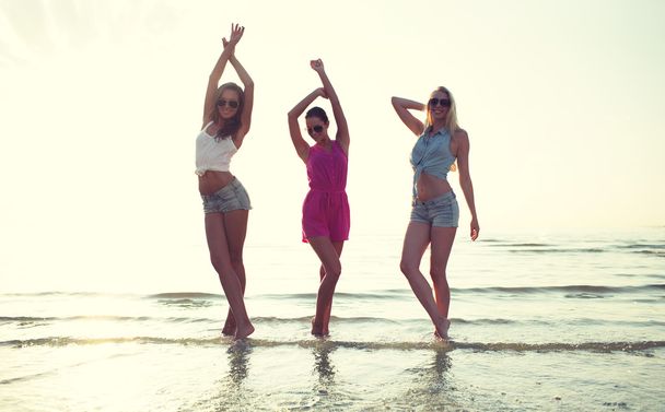 glückliche Freundinnen tanzen am Strand - Foto, Bild