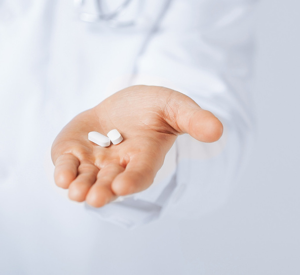 orvos kezet ad fehér tabletta  - Fotó, kép