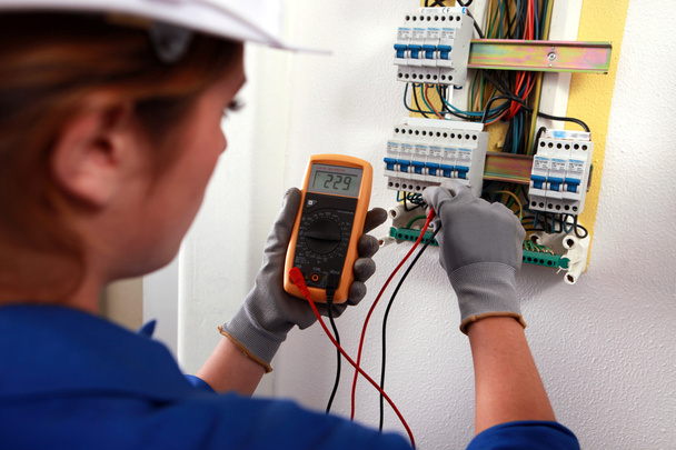 Female electrician checking a fusebox - Foto, afbeelding