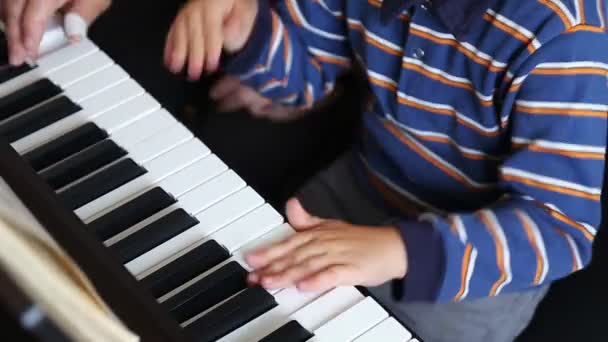 Poika opettelee soittamaan pianoa.
 - Materiaali, video