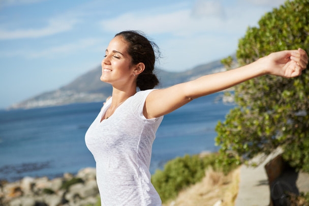 happy woman stretching her arms near the ocean - Photo, Image