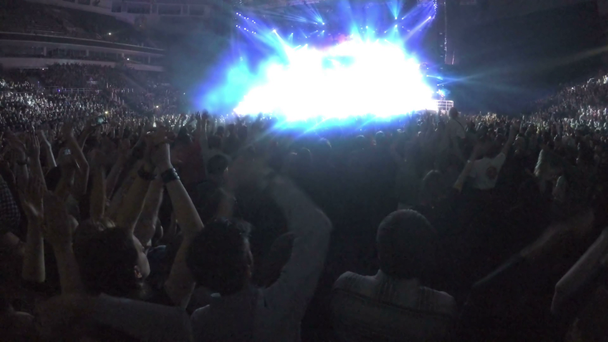 Veel opgewonden mensen die genieten van het concert, applaudisseren zwaaiende handen, rockstar op het podium - Video