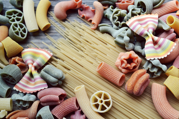 Set di diversi tipi di pasta italiana colorata su tavola di legno
 - Foto, immagini