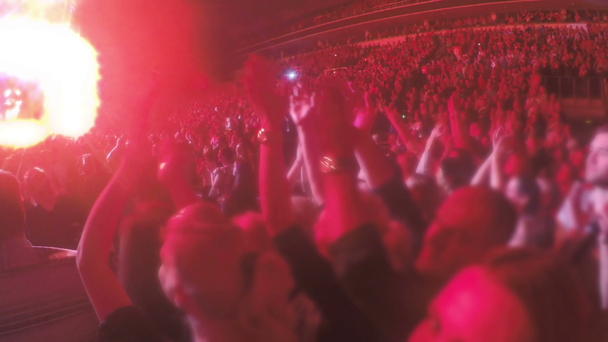 Фанаты аплодируют популярной группе на ярко освещенной сцене. Шоу на стадионе
 - Кадры, видео