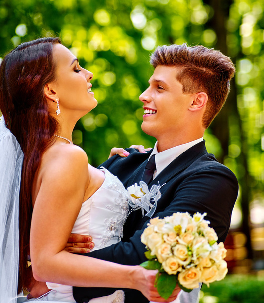 Mariée et marié avec des fleurs en plein air
. - Photo, image
