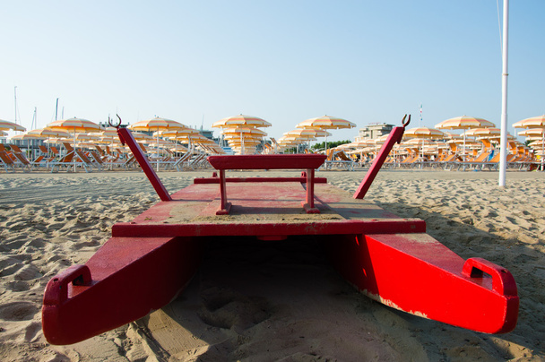 Ταξίδια παραλία Romagna - παραλία και τη θάλασσα στο Ρίμινι με κόκκινο διάσωσης closeup βάρκα - Φωτογραφία, εικόνα
