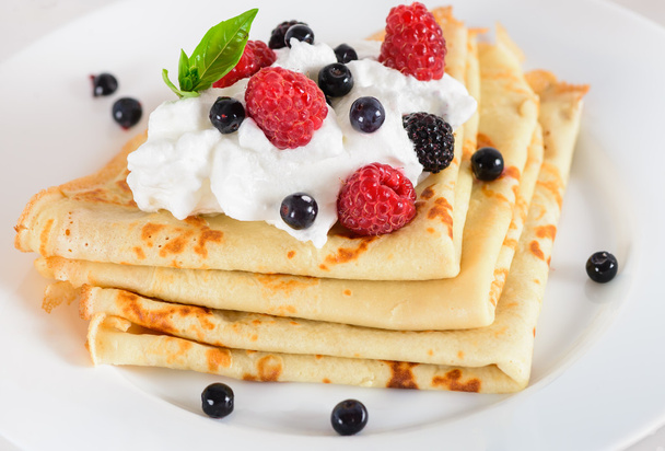 Delicious sweet crepes decorated air cream and ripe berries - Foto, afbeelding