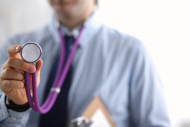 Arzt hält ein Stethoskop in der Hand und hört dem Herzschlag zu - Foto, Bild