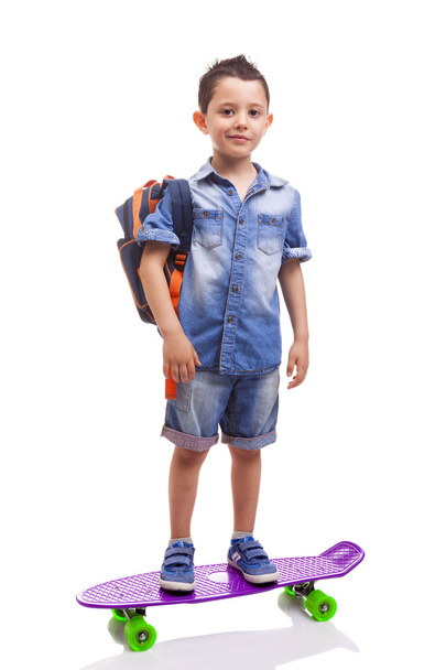 Schoolkid standing with a skateboard and backpack - Photo, Image