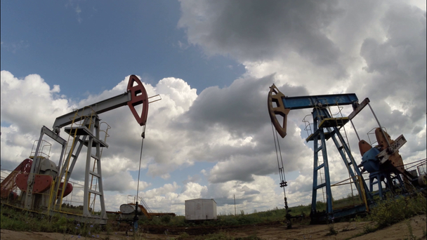 Ölpumpen. Ausrüstung der Ölindustrie. Gewitterwolken. bewegliche Kamera - Filmmaterial, Video