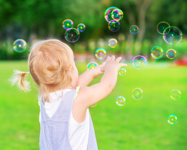 Baby girl play with soap bubbles - Фото, изображение