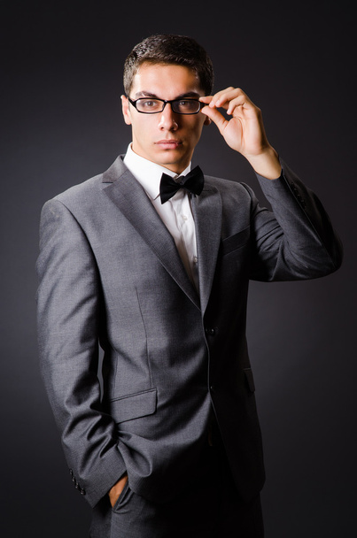 Young elegant man against gray - Фото, изображение