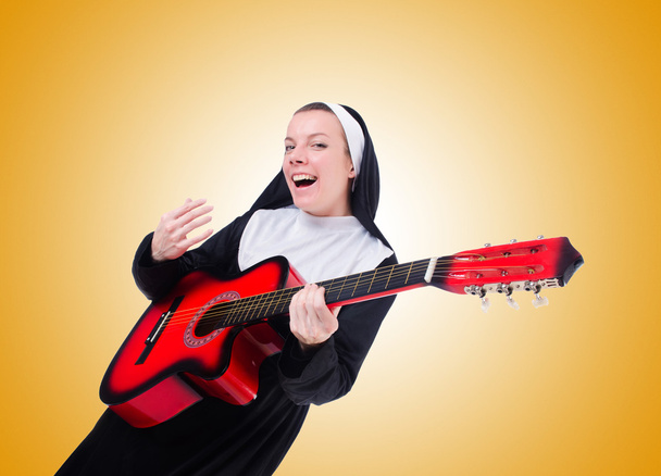 Nun playing guitar against the gradient  - Fotografie, Obrázek