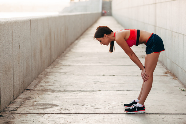 Young caucasian woman taking breath after jogging - Фото, зображення