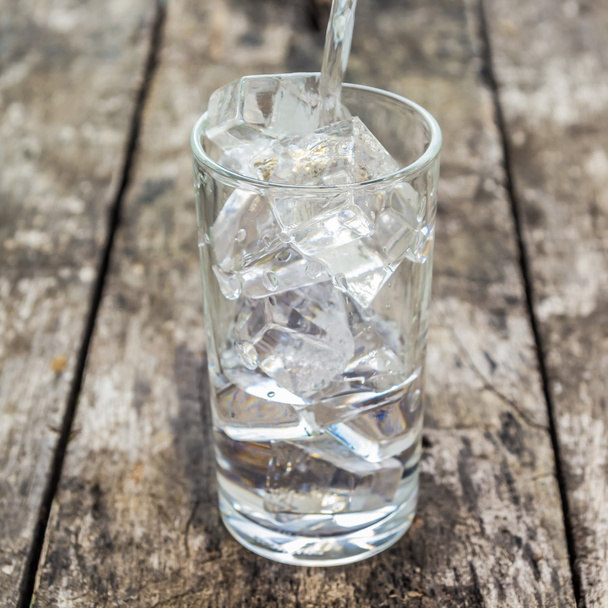 Налийте воду в склянку льоду
 - Фото, зображення