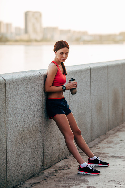 Female runner with bottled water tired - Foto, Bild