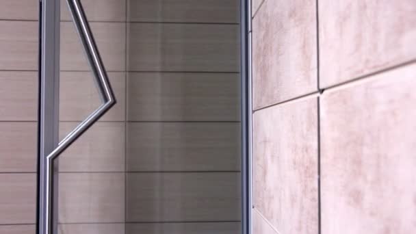 Женщина выходит через стеклянную дверь с эффективным дизайном
 - Кадры, видео