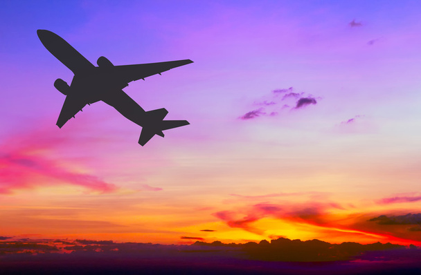 Silhouetted εμπορικό αεροπλάνο που φέρουν στο ηλιοβασίλεμα - Φωτογραφία, εικόνα