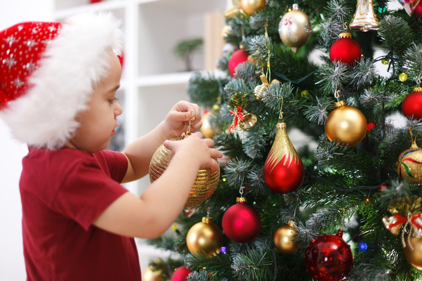 Little boy decorating Christmas tree - Fotoğraf, Görsel