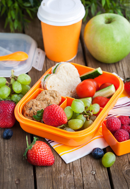 Lunchbox met sandwich, koekjes, groenten en fruit - Foto, afbeelding