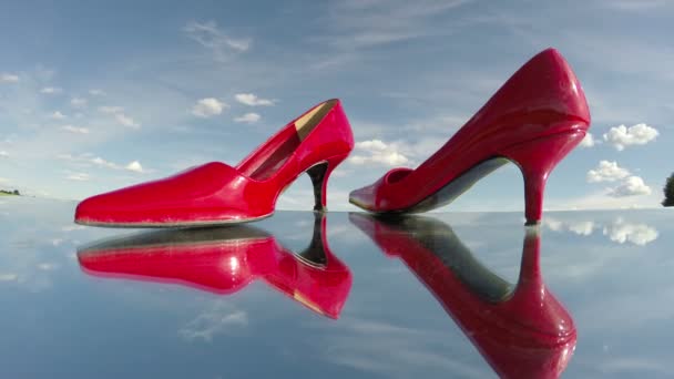 par stilettos de zapatos de mujer roja en movimiento espejo y nubes. Concepto de moda. Timelapse 4K
 - Metraje, vídeo