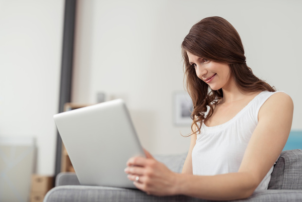 Attractive Young Woman Using Laptop at the Couch - Foto, afbeelding