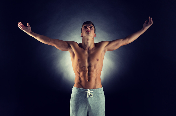 young male bodybuilder with raised hands - Zdjęcie, obraz