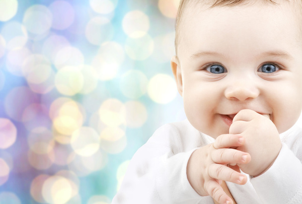 happy baby over blue holidays lights background - Foto, immagini