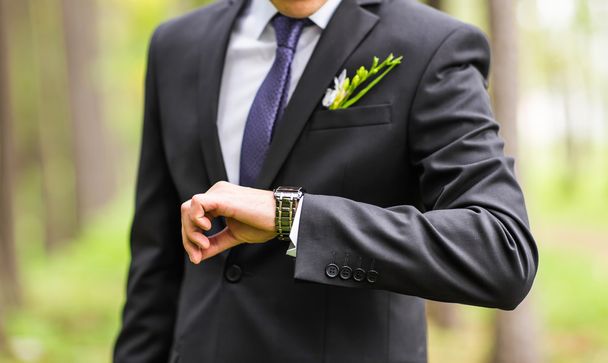 Giovane uomo d'affari guardando orologio su sfondo bianco
 - Foto, immagini