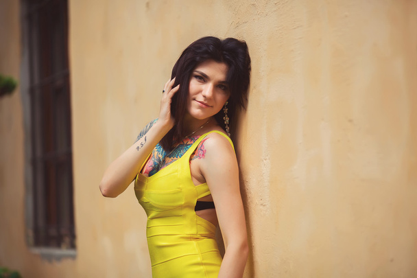 beautiful girl in a yellow dress leaned on Stan, the old town lv - Foto, Bild