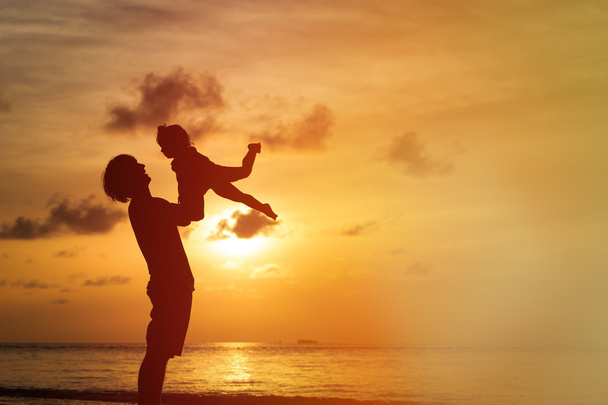 Édesapja és a kis lánya sziluettek a naplemente - Fotó, kép