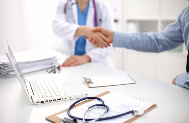 Attrayant médecin féminin serrant la main d'un patient dans son bureau
 - Photo, image