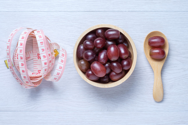 Red grapes in wooden bowl and spoon - Photo, Image