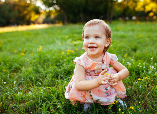 Little girl sitting on the grass. - Foto, Imagem