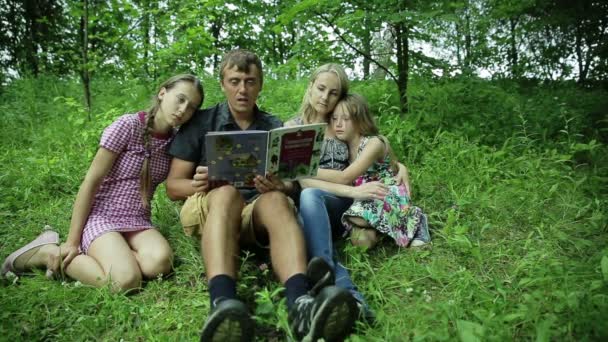 Šťastné rodinné čtení knih v parku - Záběry, video