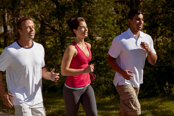 Drie atletische vrienden joggen in het Park - Foto, afbeelding