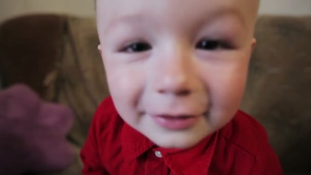 ευτυχισμένος μικρό αγόρι με ένα κόκκινο πουκάμισο - Πλάνα, βίντεο