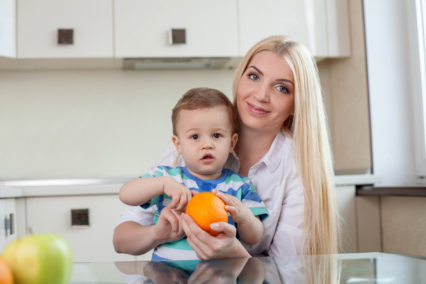 Cheerful young mom is feeding her son - Foto, immagini