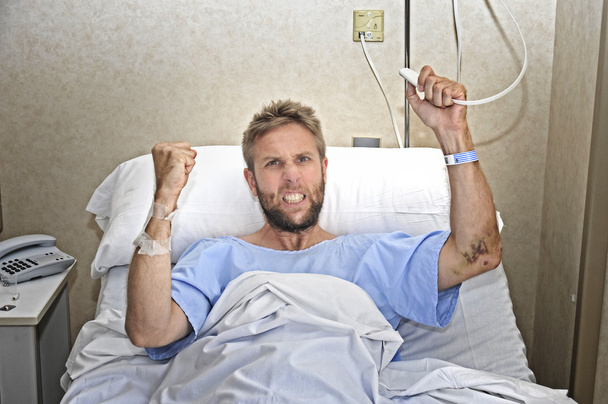 zły człowiek cierpliwy w szpitalnej sali leżąc w łóżku naciskając pielęgniarki połączeń przycisk uczucie nerwowego i zdenerwowany - Zdjęcie, obraz