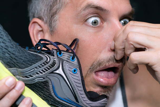 Άνθρωπος Gags μετά μυρίζοντας παπούτσι - Φωτογραφία, εικόνα