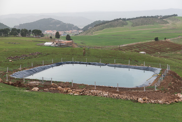 Het door de mens veroorzaakte zwembad voor de landbouw met behulp van plastic folie - Foto, afbeelding