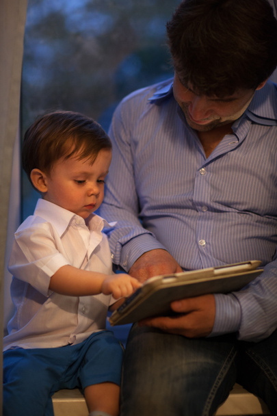 Mann und kleiner Junge spielen mit Tablet - Foto, Bild